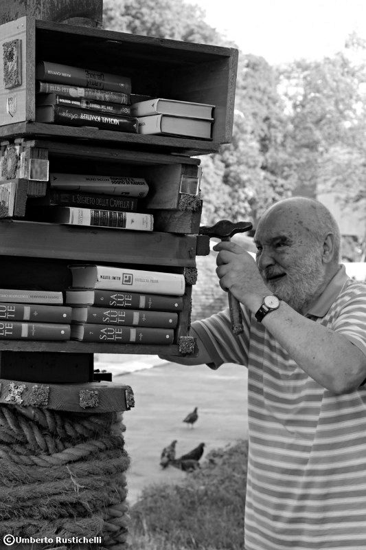 Venice, an old man taking care of a small niche for book exchange
