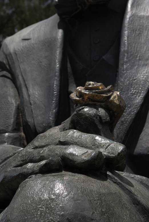 un fiore nella mano di una statua a Villa Borghese